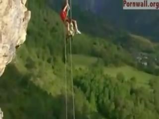 Akrobatické pár súložiť cez the cliff pokles